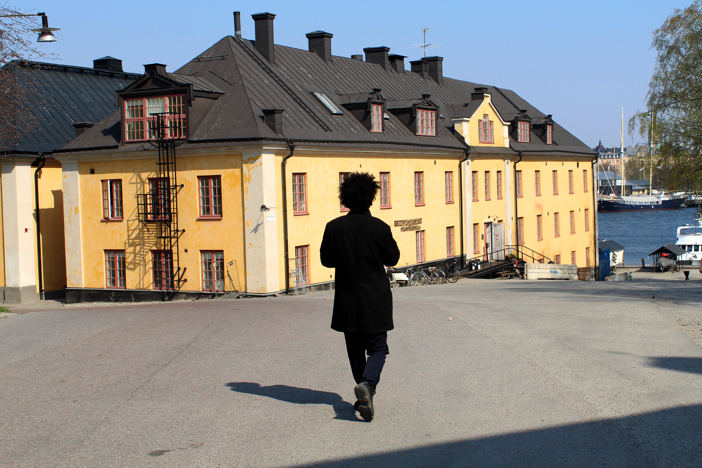 Exteriör på skolbyggnad med deltagare som går mot skolan